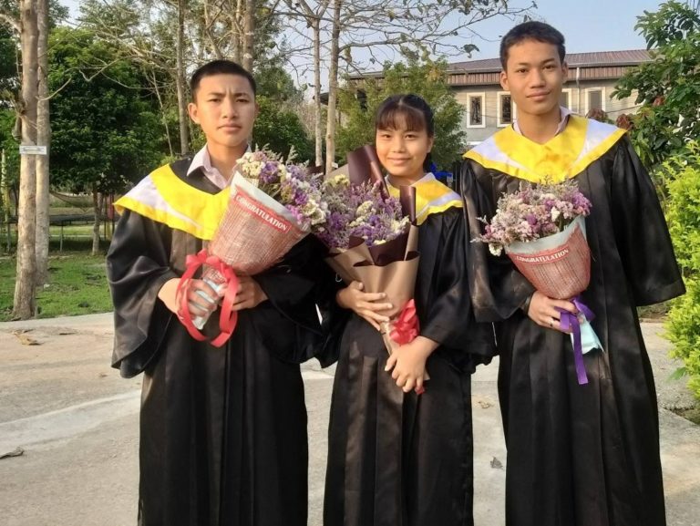 three kids in graduation gowns 2022 crop